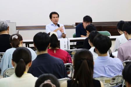 　大学生らに向けて話す平良卓也弁護士（奥左）＝６日午後、石川県輪島市
