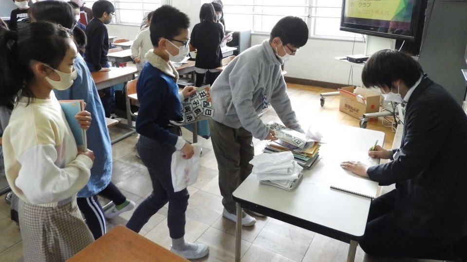 担任に冬休みの宿題を提出する児童たち＝岐阜市白山町、白山小学校