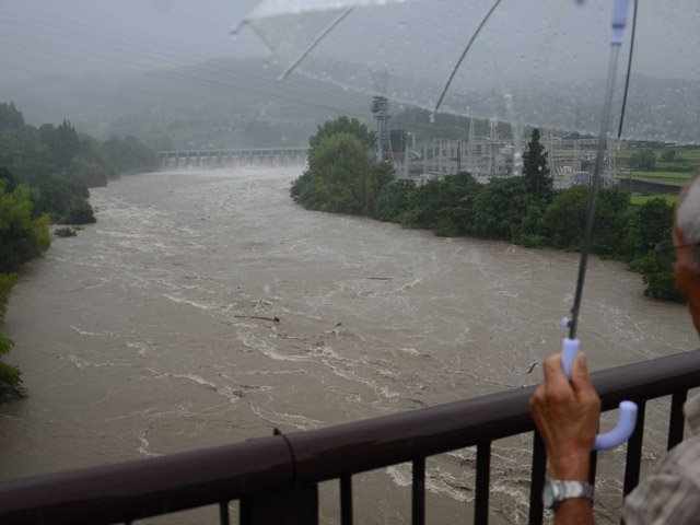 木曽川が氾濫危険水位を超え、心配そうに落合ダムを眺める地元住民＝中津川市瀬戸