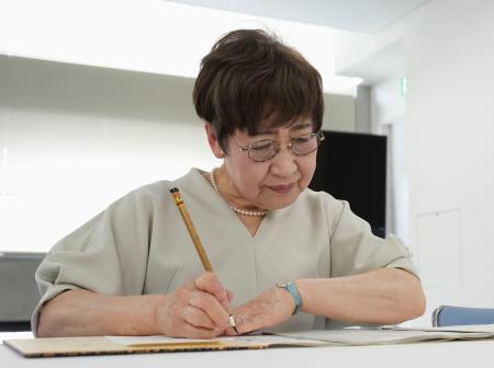 　原爆死没者名簿に名前を書き加える森田孝子さん＝１日午前、長崎市役所