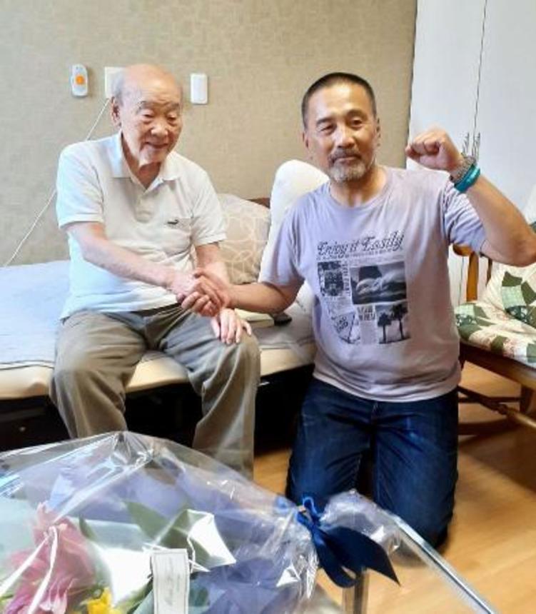 　高齢者施設で暮らす父親礼三さん（左）と面会した前川彰司さん＝１９日午後、福井市（前川彰司さん提供）