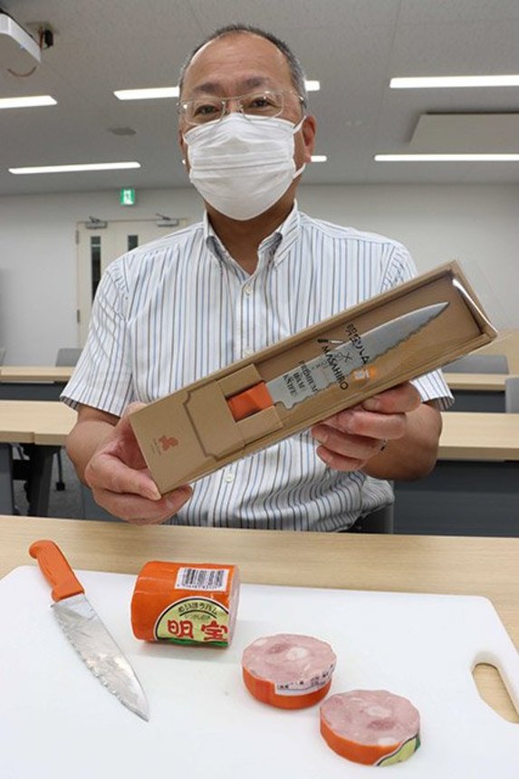 プレミアムハムナイフを披露する名畑和永専務＝郡上市明宝気良、明宝特産物加工