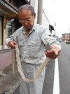 ヘビの抜け殻を見つけた橋本英雄さん＝同