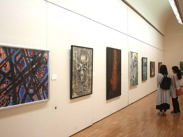 開幕した県アンデパンダン展で、作品に見入る来場者＝岐阜市宇佐、県美術館