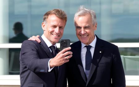 　写真を撮るカナダのカーニー首相（右）とフランスのマクロン大統領＝２０日、フランス領の群島サンピエール・ミクロン（Ａｄｒｉａｎ　Ｗｙｌｄ／カナダ通信提供・ＡＰ＝共同）
