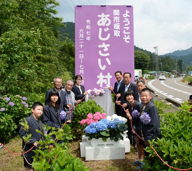 「あじさい村」をＰＲする看板を除幕した関係者たち＝関市板取