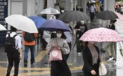 雨の中、傘を差して歩く人たち＝２日午前７時３８分、岐阜市神田町、名鉄岐阜駅前