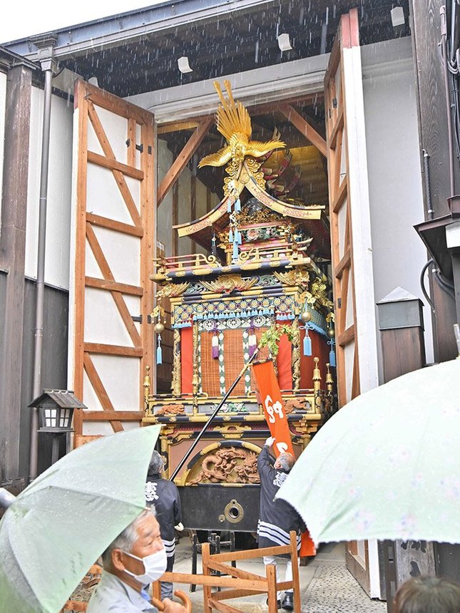 雨の中、蔵から姿を見せた祭り屋台＝１４日午前８時３７分、岐阜県高山市上三之町、恵比須台