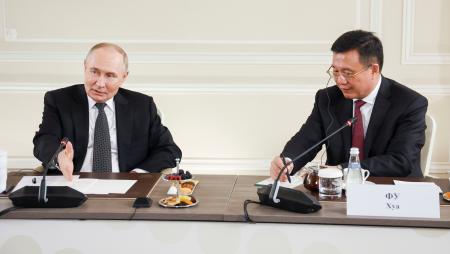 　１９日未明、ロシア北西部サンクトペテルブルクで行われた各国通信社代表との会見で質問に答えるプーチン大統領。右は中国国営通信新華社の社長（ロシア大統領府提供・タス＝共同）