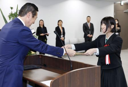 　総理大臣表彰を黄川田こども政策相（左）から受ける楊志館高「徳育宣隊」の代表者＝２７日午前、東京・霞が関