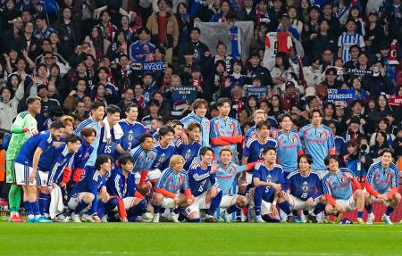 　サッカー国際親善試合でイングランドから初勝利を挙げ、サポーターと写真に納まる日本代表の選手たち＝３月３１日、ロンドンのウェンブリー競技場（共同）