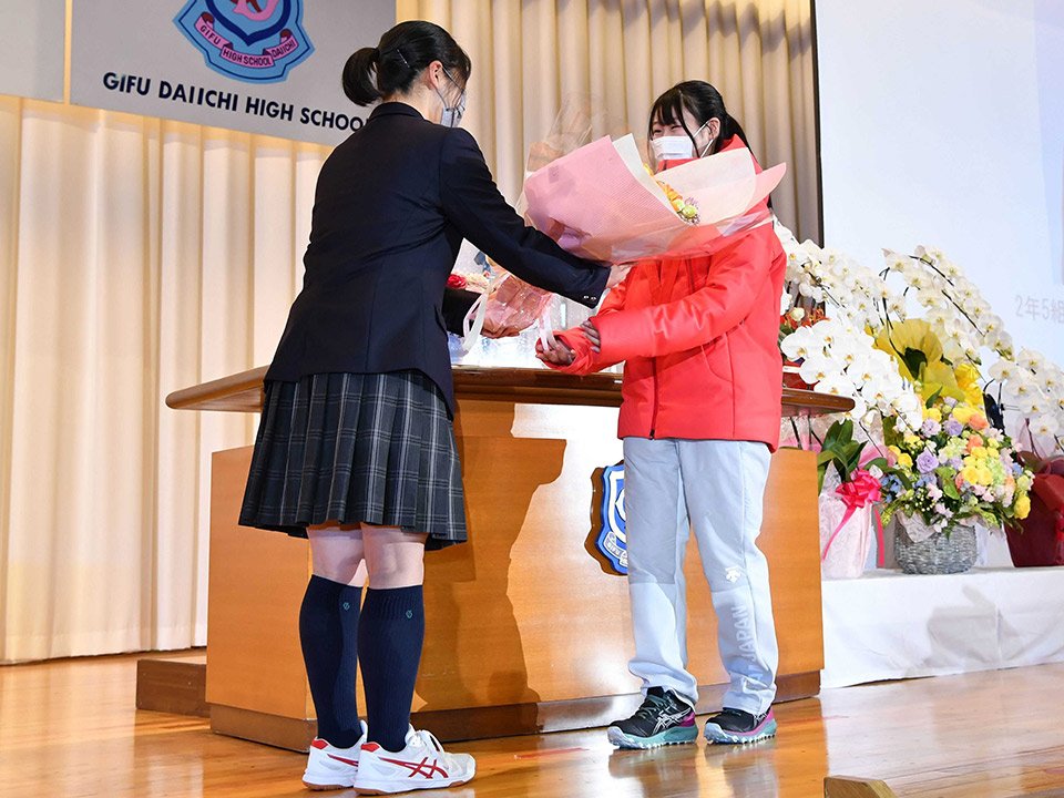 代表生徒から花束を受け取る村瀬心椛選手（右）＝２８日午前８時５７分、本巣市仏生寺、岐阜第一高校