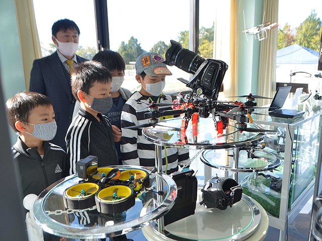 展示のドローンに見入る親子＝１３日、美濃市曽代、ドローンミュージアム＆パークみの