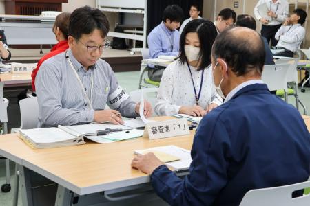 　鳥取県議補選で、立候補者の「２馬力」防止のための宣誓書などを確認する県選管の職員＝１６日午前、鳥取県米子市