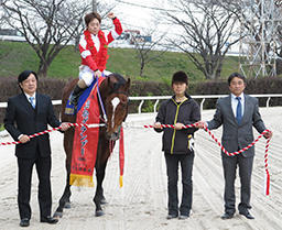 優勝したラブバレットに乗ってガッツポーズを見せる山本聡哉騎手と関係者