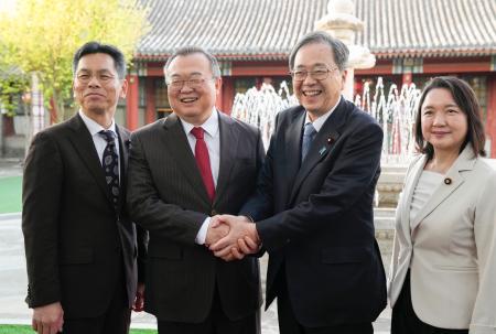 　握手する公明党の斉藤代表（中央右）と中国共産党中央対外連絡部の劉建超部長（同左）＝２２日、北京（共同）