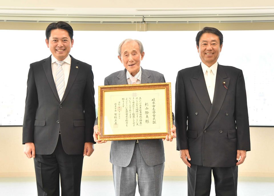 岐阜市名誉市民証を柴橋正直市長（左）らから受け取った杉山幹夫岐阜新聞社最高顧問（中央）＝岐阜新聞本社