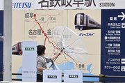 台風７号接近に伴う風で傘が飛ばされそうになる人の姿も＝１５日午前９時５７分、岐阜市神田町