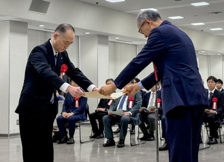 　大阪国税局で開かれた「清酒鑑評会」の表彰式で、表彰状を受け取る白鶴酒造の関係者（左）＝３０日午前、大阪市中央区