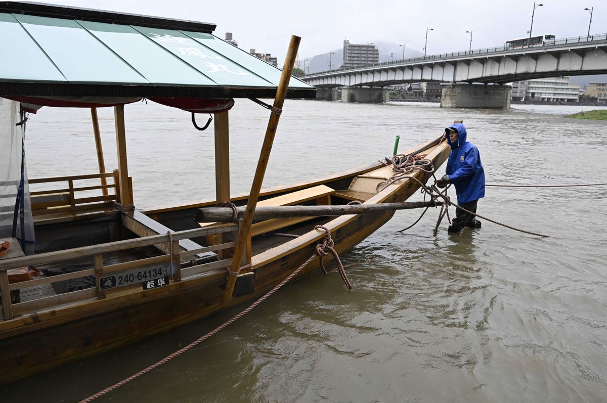 台風接近に伴う大雨により冠水した乗船場で鵜飼観覧船を係留する関係者＝２６日午後３時５８分、岐阜市湊町