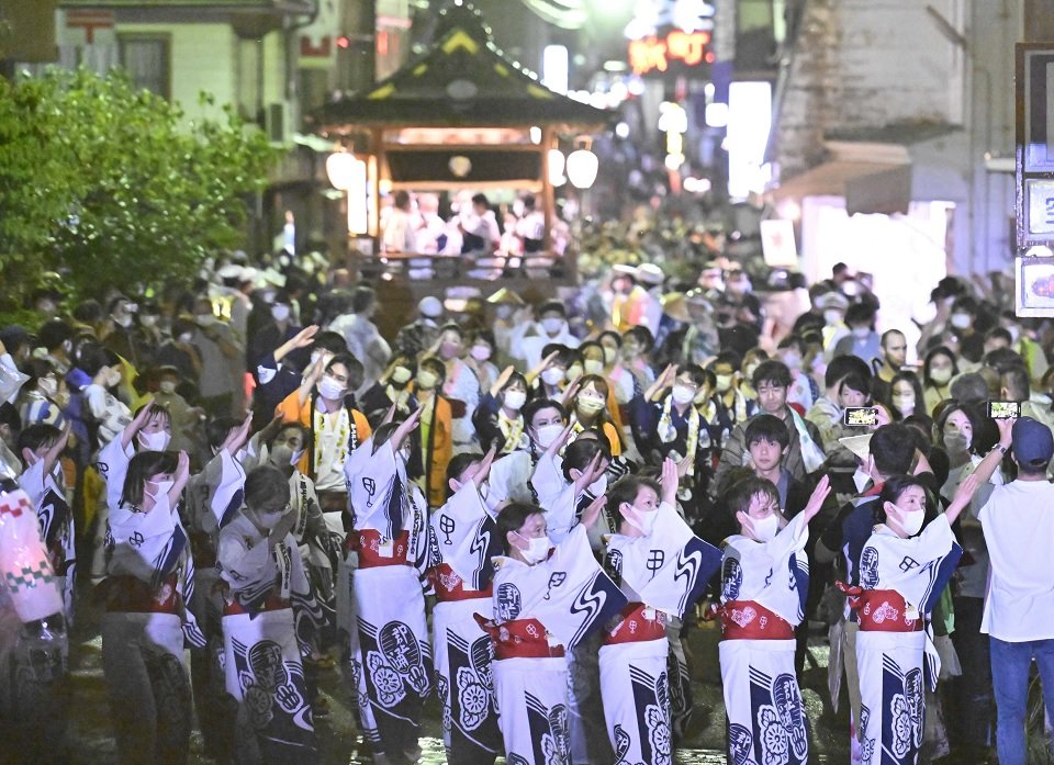 踊りながら郡上おどり会場に向かう人たち＝９日午後７時５２分、岐阜県郡上市八幡町