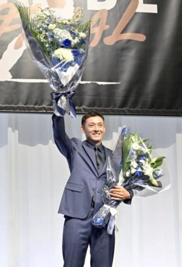　引退試合を前に開かれた記者会見で、花束を手にする西武の栗山巧外野手＝３０日、東京都内