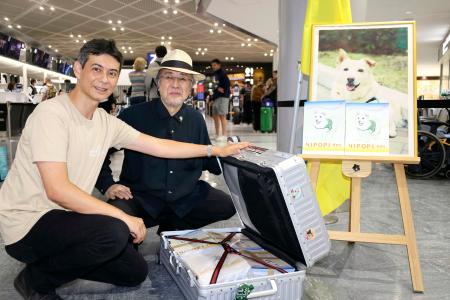 　絵本「チロリ」をウクライナに送る大木トオルさん（右）＝６月３０日、成田空港