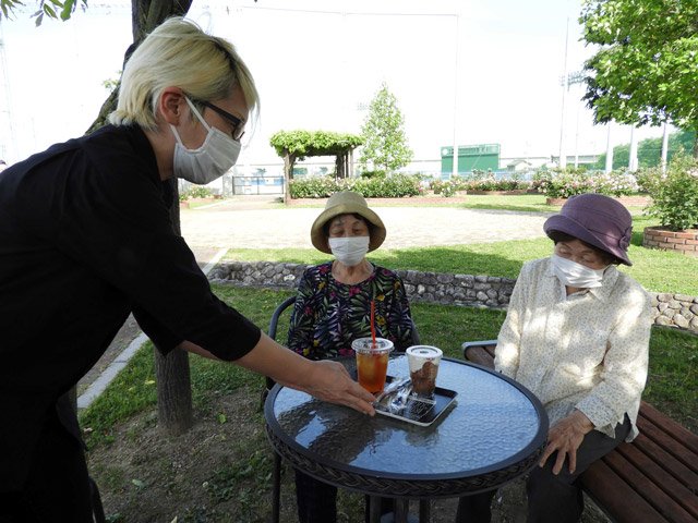 期間限定オープンの「薔薇ｃａｆｅ」のメニューを手渡す小寺聡美さん＝同