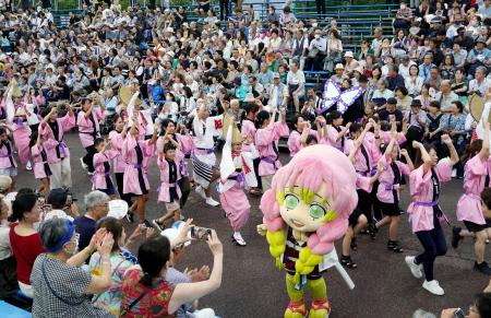 　徳島市の阿波おどりで、人気アニメ「鬼滅の刃」のキャラクター着ぐるみと一緒に踊りを披露する人たち＝１２日午後