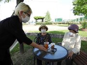 期間限定オープンの「薔薇ｃａｆｅ」のメニューを手渡す小寺聡美さん＝同