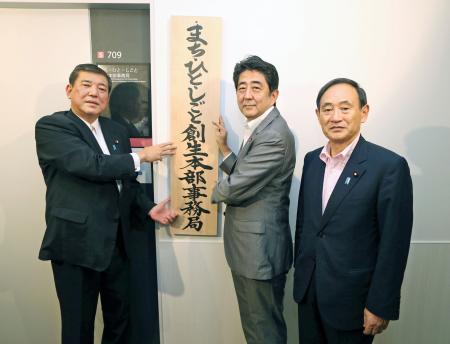 　「まち・ひと・しごと創生本部事務局」の看板を掛ける（左から）石破茂地方創生相、安倍晋三首相、菅義偉官房長官＝２０１４年９月、代表撮影、肩書きは当時