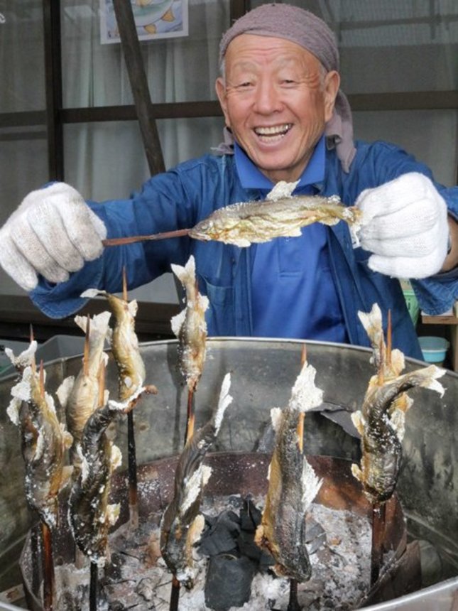 「鮎を食べた人がおいしさに驚く顔を見るのが楽しい」と笑う室田正さん＝飛騨市宮川町西忍