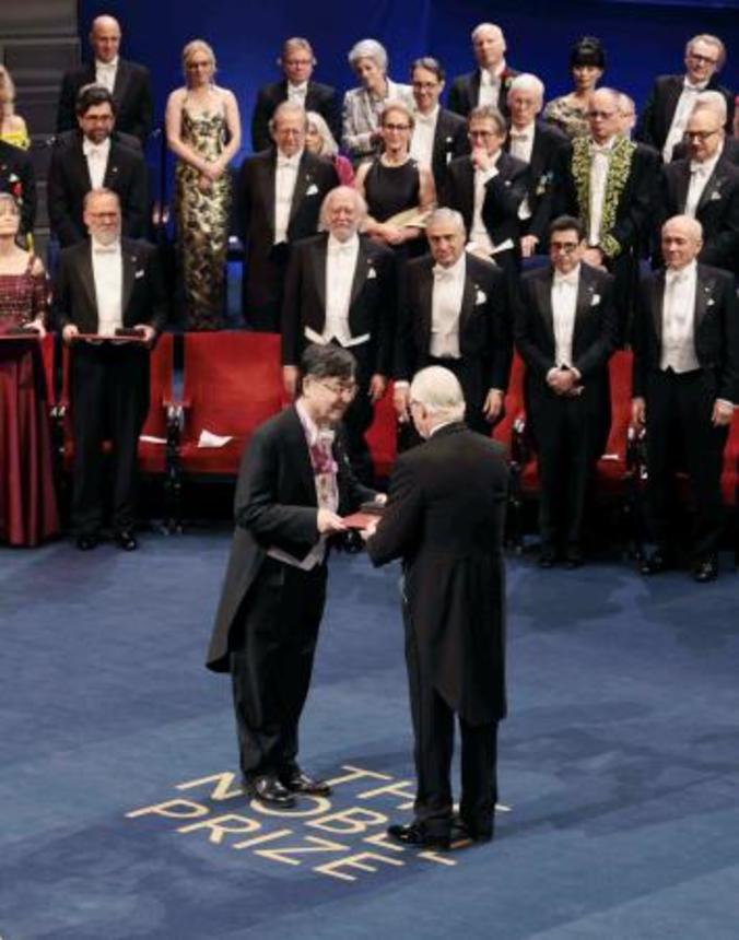 　ノーベル賞授賞式で、スウェーデンのカール１６世グスタフ国王（手前右）から生理学・医学賞のメダルと賞状を授与される坂口志文・大阪大特任教授（同左）＝１０日、ストックホルムのコンサートホール（代表撮影・共同）