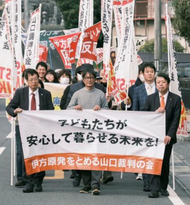 　伊方原発３号機の運転差し止めを求めた訴訟の判決で、山口地裁岩国支部に向かう原告ら＝２６日午前