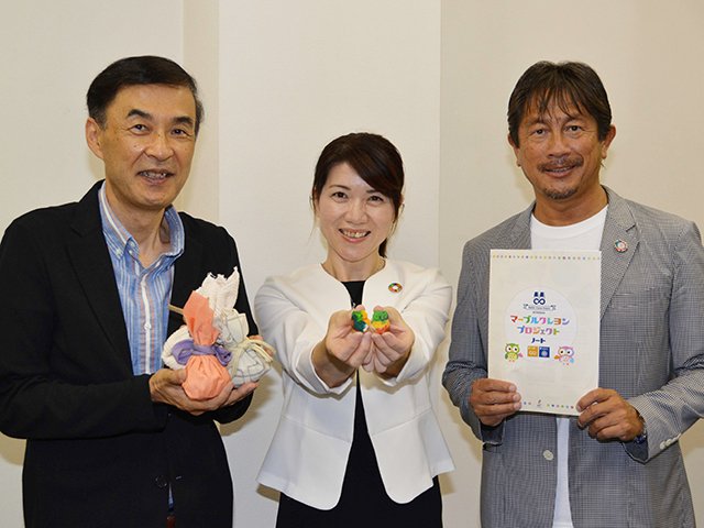 再生したクレヨンや包む布、配るノートを手にする（左から）墨勇志社長、金森律子社長、田中信康取締役専務執行役員＝大垣市内