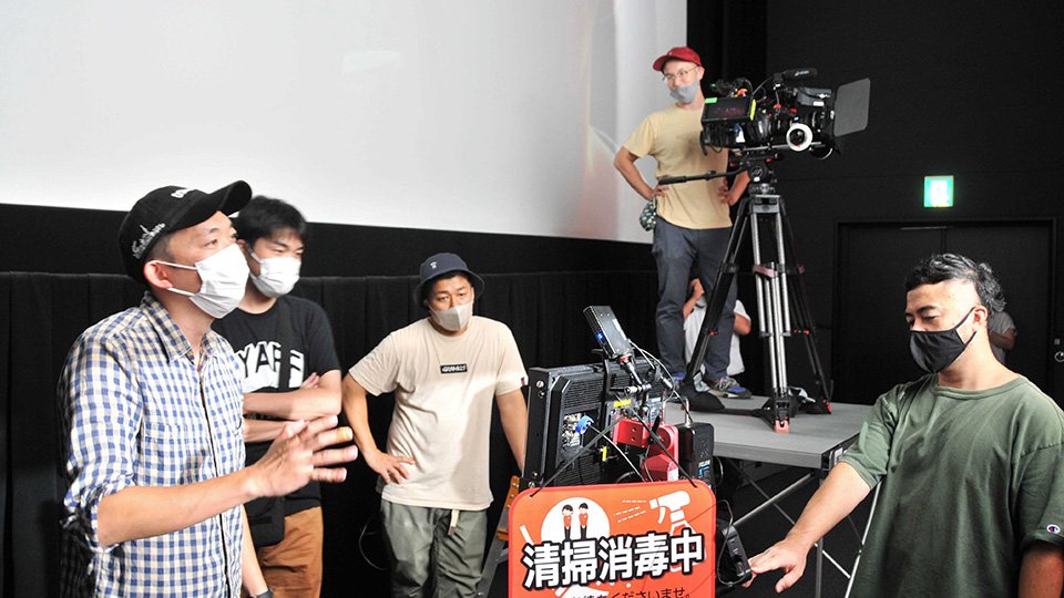 撮影した映像を確認しながらエキストラに指示を出す八木順一朗さん（左）＝関市倉知、シネックスマーゴ