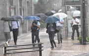 　大雨の中、傘を差して歩く人たち＝１１日午後３時３４分、東京都中央区