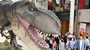 「ジュラシックアーケード」でティラノサウルスを見上げる人たち＝２４日午後２時３０分、岐阜市柳ケ瀬通