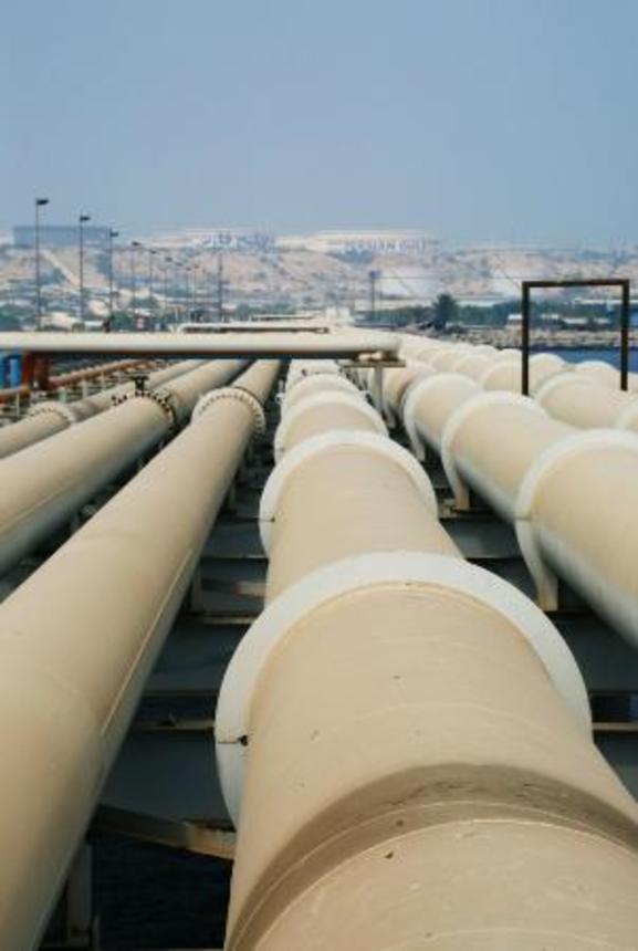 　タンカーが接岸する岸壁に原油を運ぶパイプライン＝２０１６年８月、イラン南部カーグ島（共同）
