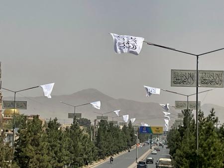　１４日、アフガニスタンの首都カブールで、復権４年を祝って掲げられたタリバンの旗（共同）