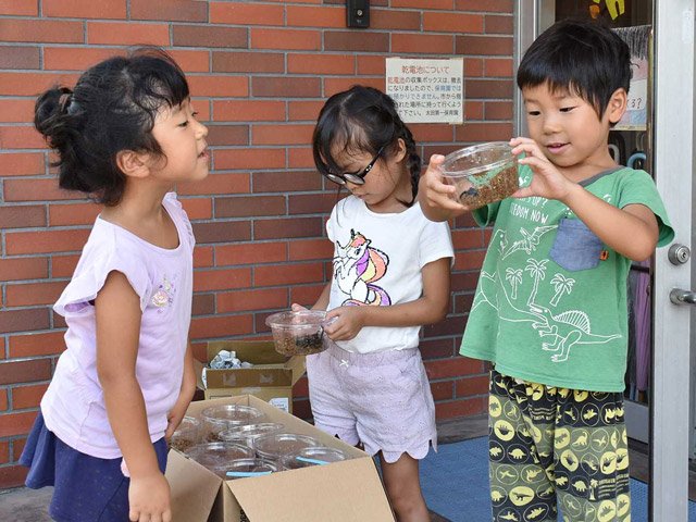 容器に入った甲虫を見て喜ぶ園児たち＝美濃加茂市太田本町、太田第一保育園