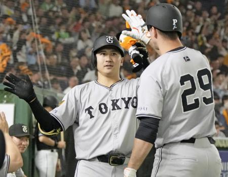 　４回、本塁打を放ち、グリフィン（右）に迎えられる巨人・泉口＝東京ドーム