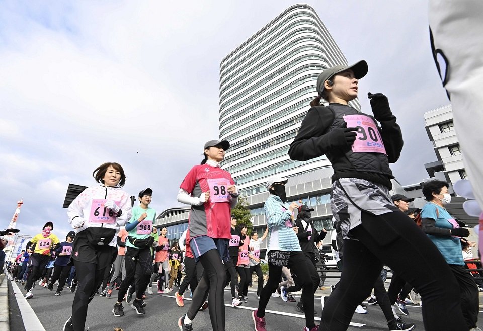 岐阜市役所前をスタートする女性ランナーたち＝１９日午前９時６分、岐阜市美江寺町