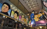 映画館があるビル１階の入り口。往年の名俳優たちを描いた絵看板が出迎えてくれる＝岐阜市日ノ出町、ロイヤル劇場