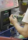　スーパーでレジに通される商品＝７月、東京都内