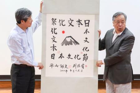 　劉江永清華大教授（右）から寄贈された平山郁夫さんの書画＝２５日、北京の北京外国語大（共同）