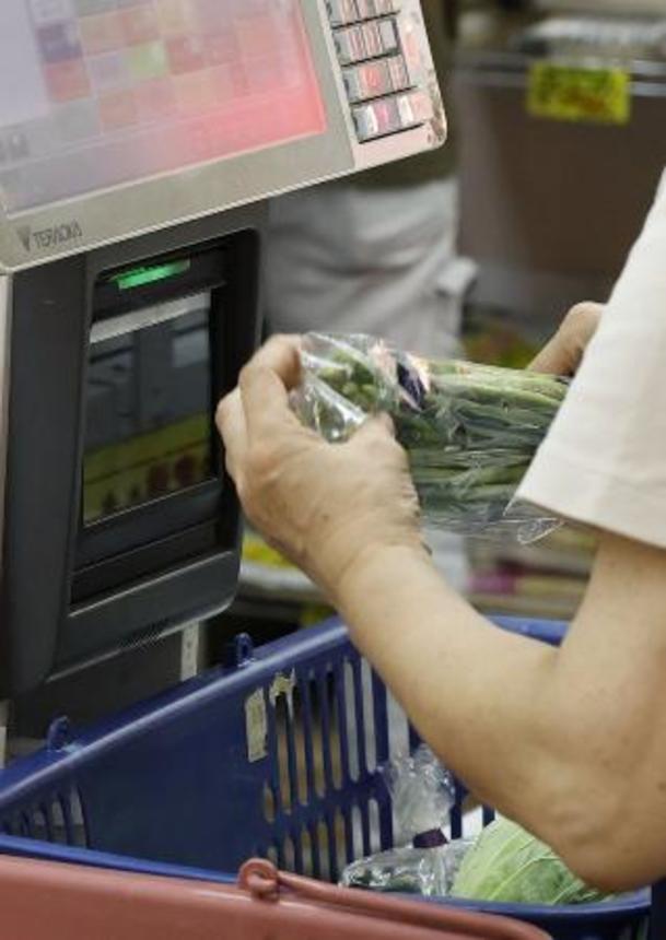 　スーパーでレジに通される商品＝７月、東京都内