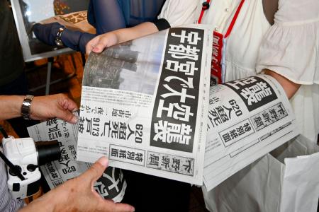 　下野新聞社がＪＲ宇都宮駅前で配布した特別紙面＝１２日午後