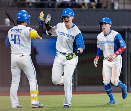 　７回、勝ち越し２ランを放ち次打者水野（左）とタッチを交わす日本ハム・清宮幸。右は五十幡＝エスコンフィールド