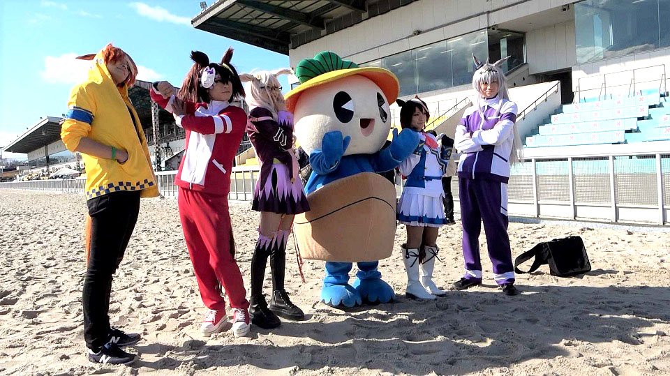 笠松町のマスコット「かさまるくん」と写真撮影する参加者＝岐阜県羽島郡笠松町、笠松競馬場